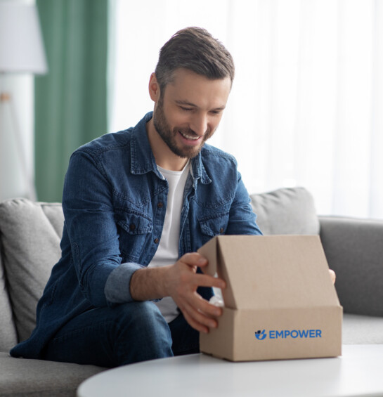 A smiling man opening a box from empower