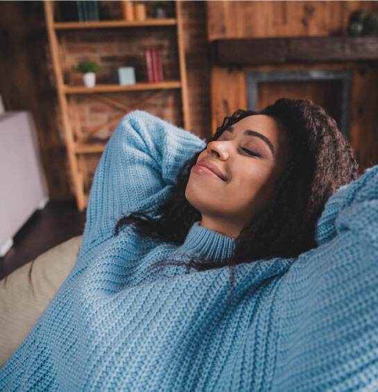 woman sitting in chair smiling with eyes closed