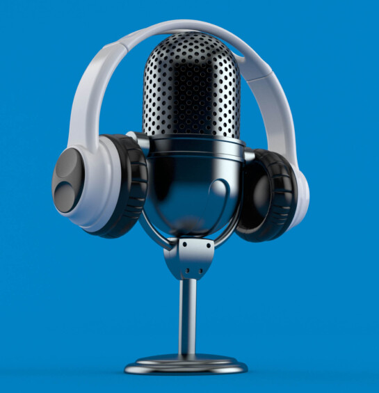 Headphones sitting in from of a podcast mic